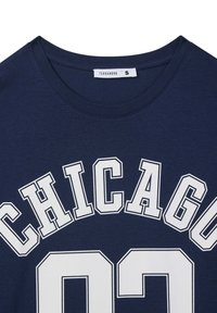 T-shirt in cotone blu navy con lettere bianche "CHICAGO" e "02", scollatura rotonda e maniche corte. L'etichetta del marchio riporta "Terranova".