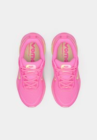 Svetlo roza športni čevlji z mrežasto zgornjim delom, okroglo konico in teksturiranim podplatom. Imajo rumene akcentne barve in vezalke, podloženi vložki z blagovno znamko.