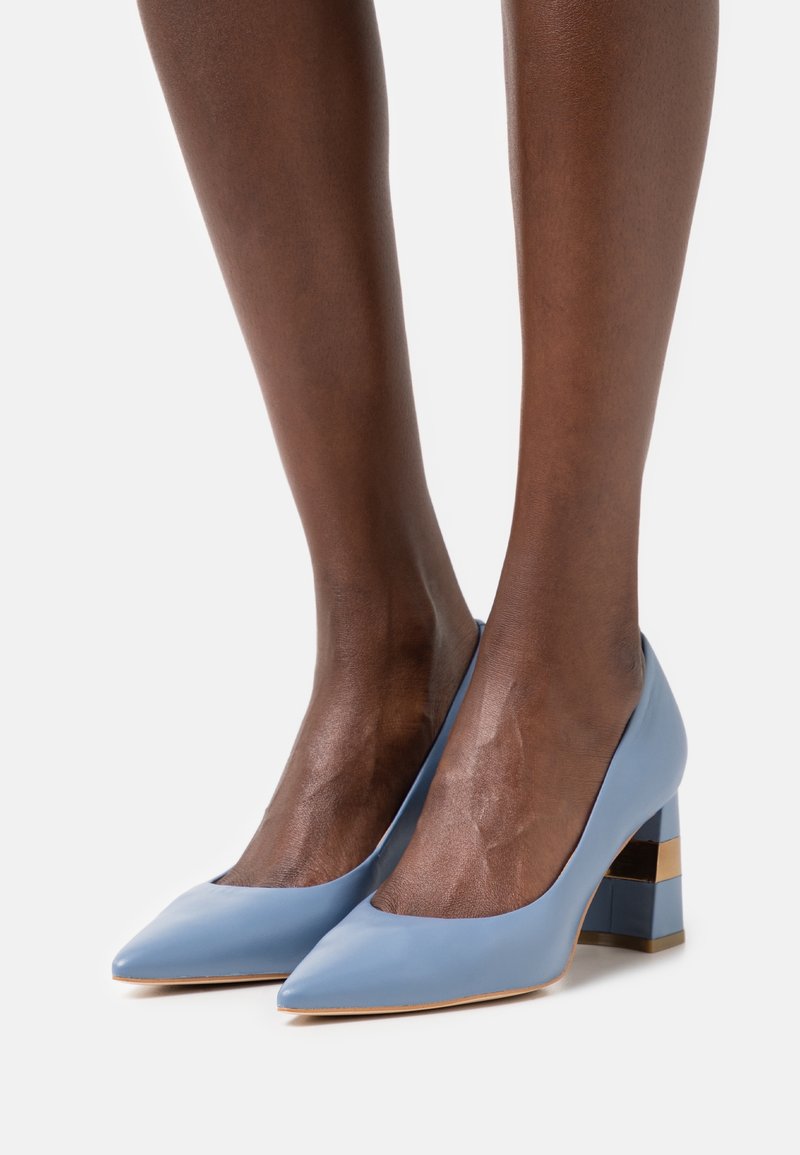 Escarpins en cuir bleu à bout pointu avec un talon géométrique épais et texturé agrémenté d'accents dorés. Finition lisse avec un design structuré.