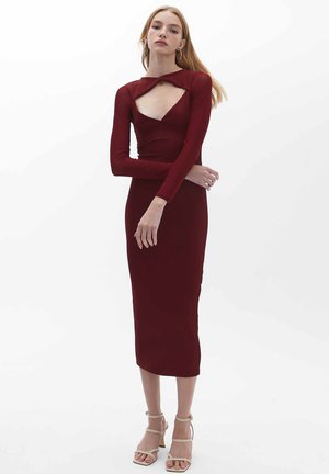 Burgunderfarbenes langärmliges Kleid mit tiefem V-Ausschnitt und Ausschnittdetail an der Brust, figurbetonte Silhouette, glatte Textur und knielanger Saum.