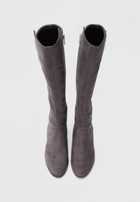 Grå mokkakåper over knelange støvler med glatt tekstur, avrundet tå og glidelåslukking på siden. Minimalistisk design og høyt skaft.