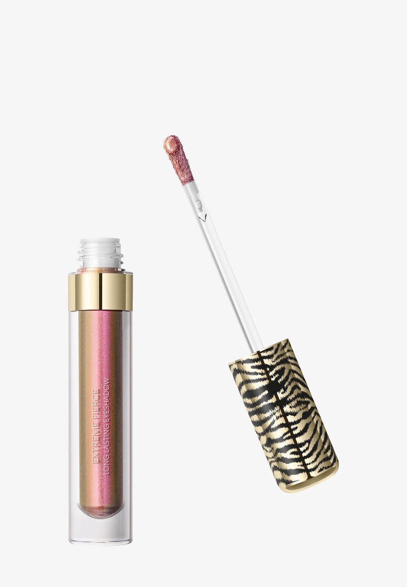 Ombre à paupières liquide rose-doré scintillante avec capuchon doré et couvercle imprimé léopard, applicateur partiellement retiré montrant le produit au bout.