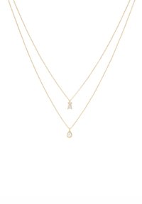 Collar de dos capas en tono dorado que presenta un colgante rectangular y otro en forma de gota, ambos con piedras transparentes, sobre delicadas cadenas de eslabones.