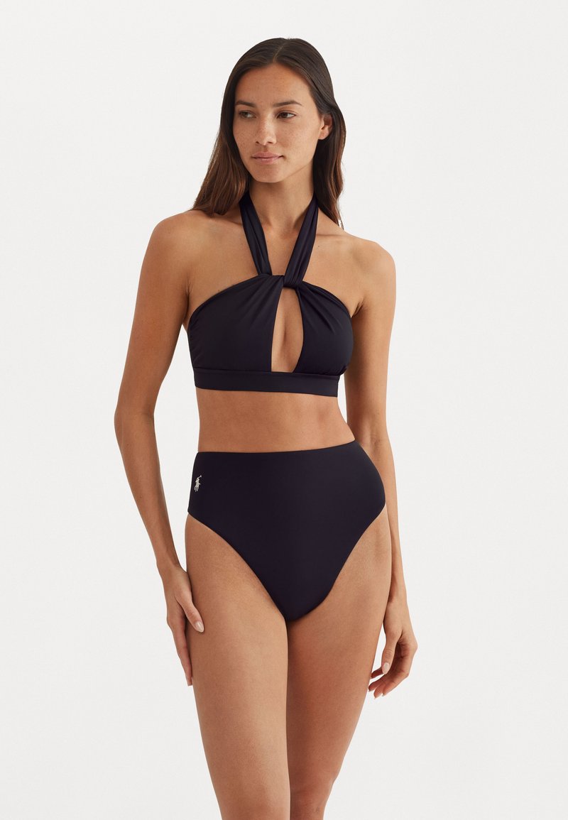 Črn bikini komplet z zgornjim delom na vrat z režo in visokim pasom. Gladka tkanina z minimalnim logotipom.