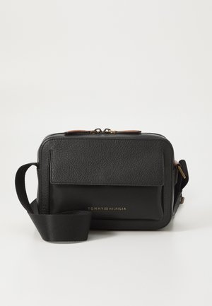 Czarna skórzana torebka na ramię z fakturowanym przodem, złotym logo, zapięciem na zamek oraz odpinanym materiałowym paskiem.