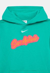 Tyrkysová mikina s kapucňou z bavlneného zmesi, s ružovo-žltou grafikou "San Antonio" a malým bielym logom Nike nad ňou.
