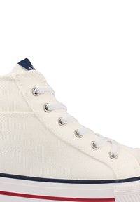 Hoge sneakers van witte canvas met een textuur, voorzien van metalen oogjes, witte veters en een blauwe en rode streep op de zool.
