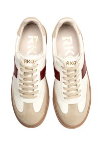 Vita lädersneakers med röda detaljer och beiga mockadetaljer. Har platta skosnören, en texturerad yta och en tan gummisula.