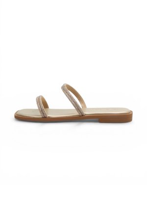 Sandalo piatto con due sottili cinturini tempestati di strass su una soletta beige e una suola bassa marrone, visto di lato su sfondo bianco.