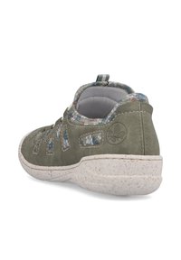 Chaussure en daim vert avec des bordures en tissu à motifs. Présente une semelle blanche texturée et des découpes pour la ventilation. L'arrière est équipé d'une boucle pour un enfilage facile.