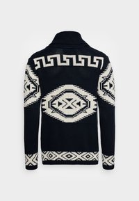 Cardigan tricoté en marine et crème. Présente des motifs géométriques, un col montant et des poignets côtelés. Confectionné en fil texturé.