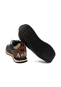 Sneakers con un design in materiali misti che includono camoscio marrone e tessuto blu navy. Presentano una suola decorata e il logo "AOM" sul tallone.