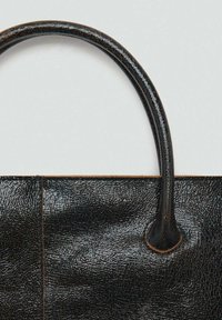 Borsa a tracolla nera in pelle con superficie texture, dotata di manici arrotondati e cuciture visibili lungo il bordo superiore. Design semplice.