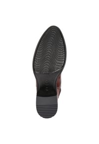 Semelle d'une chaussure en cuir marron avec un fond en caoutchouc noir texturé, présentant des rainures linéaires et une forme arrondie, conçue pour l'adhérence.