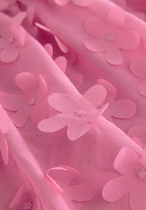 Tissu rose avec des appliqués floraux tridimensionnels en couches et des centres cousus. Texture douce avec des éléments transparents, créant de la profondeur.