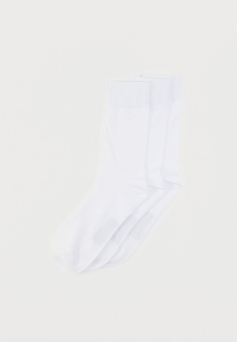 Chaussettes blanches en coton avec une texture lisse, des bords côtelés et des bouts sans coutures. Deux paires présentées côte à côte sur un fond neutre.