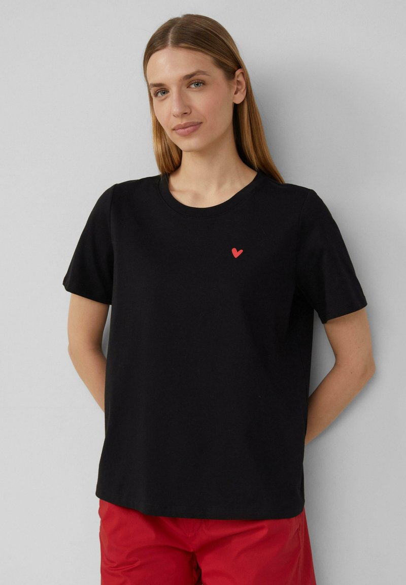 Czarny bawełniany t-shirt z krótkimi rękawami, okrągłym dekoltem i małym czerwonym sercem na piersi. Gładka struktura, luźny krój.