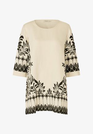 Túnica crema con patrones de flores y bordes geométricos negros en las mangas y el dobladillo, con cuello redondo y mangas tres cuartos.