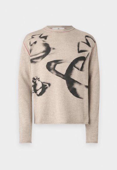 Beige tröja gjord av mjukt tyg, med abstrakta svarta mönster. Den har en rundad nacke och röd sömnad längs sömmarna.