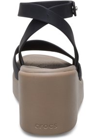 Sandalo nero con cinturini e una larga piattaforma beige, caratterizzato da una superficie liscia e un logo discreto sul tallone.