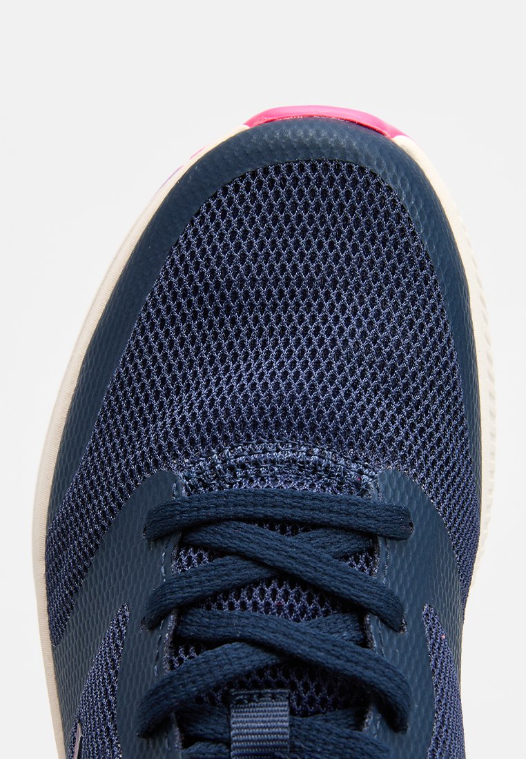 Bottines de sport en mesh marine avec lacets, surface texturée, accent rose à la pointe et semelle en caoutchouc blanche. Présente un détail de logo sur le côté.