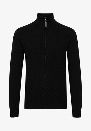 Zwarte zip-up sweater met een hoge kraag, voorzien van een gestructureerd zigzagpatroon en ribgebreide manchetten en onderkant. Gemaakt van gebreid materiaal.
