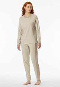 Beige Loungewear-Set mit einem Langarmshirt mit rundem Halsausschnitt und passender Hose mit gerippten seitlichen Einsätzen und umschlagenen Säumen.