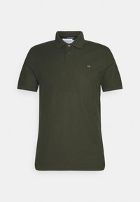 Polo vert foncé en coton, avec un col classique, une patte à deux boutons et un petit logo blanc sur la poitrine.