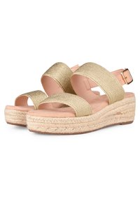 Sandali con cinturino intrecciato in oro, dotati di una soletta imbottita beige e di una suola a zeppa avvolta in juta in stile espadrillas. Cinturino regolabile alla caviglia con fibbia in metallo.