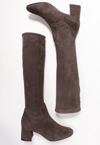 Bottes en daim marron au-dessus du genou avec un épais talon bloc, présentant une texture lisse et une silhouette ajustée. Aucune garniture ou motif visible.