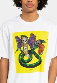 White cotton t-shirt featuring a colorful graphic of a snake and butterfly with intricate patterns on a bright yellow background.