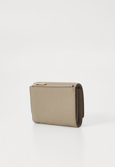 Portefeuille en cuir tan avec une surface texturée, fermeture zippée et un profil fin. Présente des accessoires en métal doré et un détail de bord cousu.