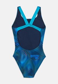 Ολόσωμο μαγιό σε ναυτικό μπλε χρώμα με έντονους γαλάζιους ιμάντες. Διαθέτει κυματιστό μοτίβο σε διάφορες αποχρώσεις του μπλε και σχέδιο με ανοικτή πλάτη.