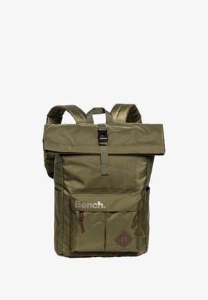 Olijfgroene rugzak met een oprolsluiting, verstelbare schouderbanden, een voorvak en een bruine leren accent aan de onderkant. Heeft een logo.