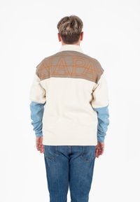 Crewneck sweatshirt met een crèmekleurig lichaam, lichtblauwe mouwen en een grijze achterpaneel met oranje 'NAPA' lettering. Gladde stof textuur.