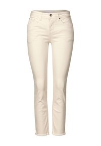 Jeans in denim di colore crema con vestibilità slim, dotati di tasche, chiusura con bottone metallico e bordi sfilacciati all'orlo.