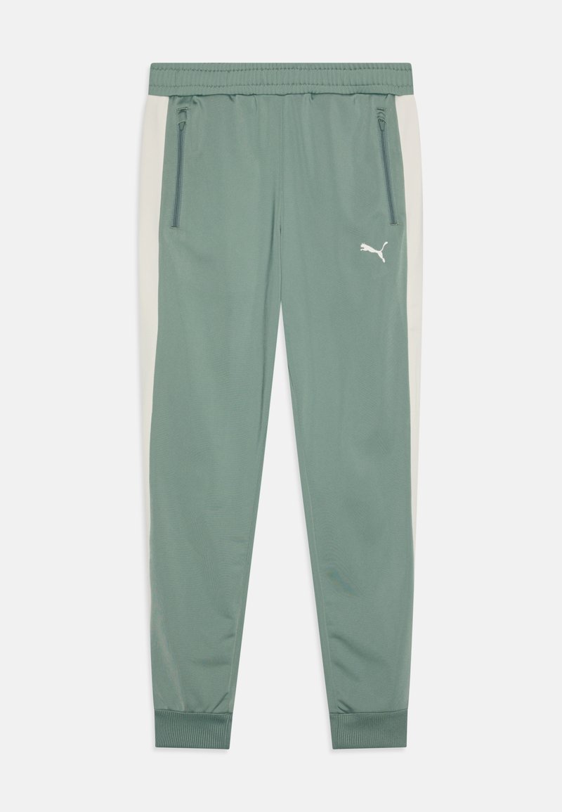 Calças de treino verdes com painéis laterais em bege claro contrastante, faixa elástica na cintura, bolsos com fecho éclair e um logo branco da Puma na coxa esquerda.