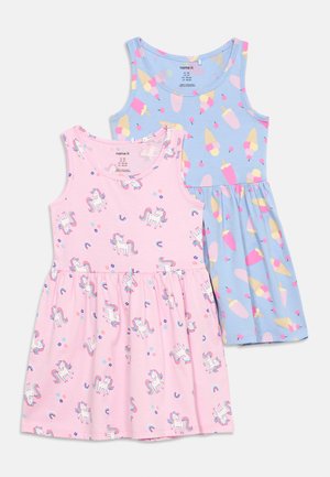 Twee mouwloze kinderkleedjes, één roze met eenhoorn- en regenboogprints, de andere blauw met ijsjes- en waterijsjespatronen.