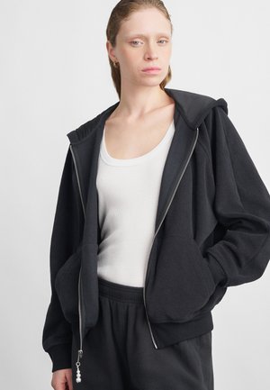 Svart zip-up hettegenser i myk stoff, med en avslappet passform, store frontlommer og en dekorativ glidelås med perler.