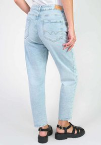 Lichtblauwe denim jeans met een relaxed fit, voorzien van een hoge taille, achterzakken met decoratieve stiksels en een leren merkpatch.