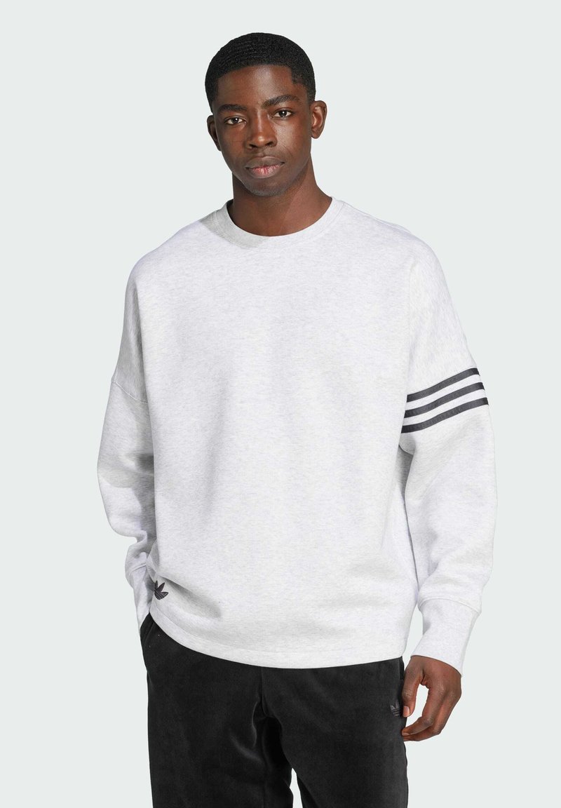 Grey sweatshirt with a round neck, featuring black striped accents on the sleeve and a small black logo at the hem. Soft texture.