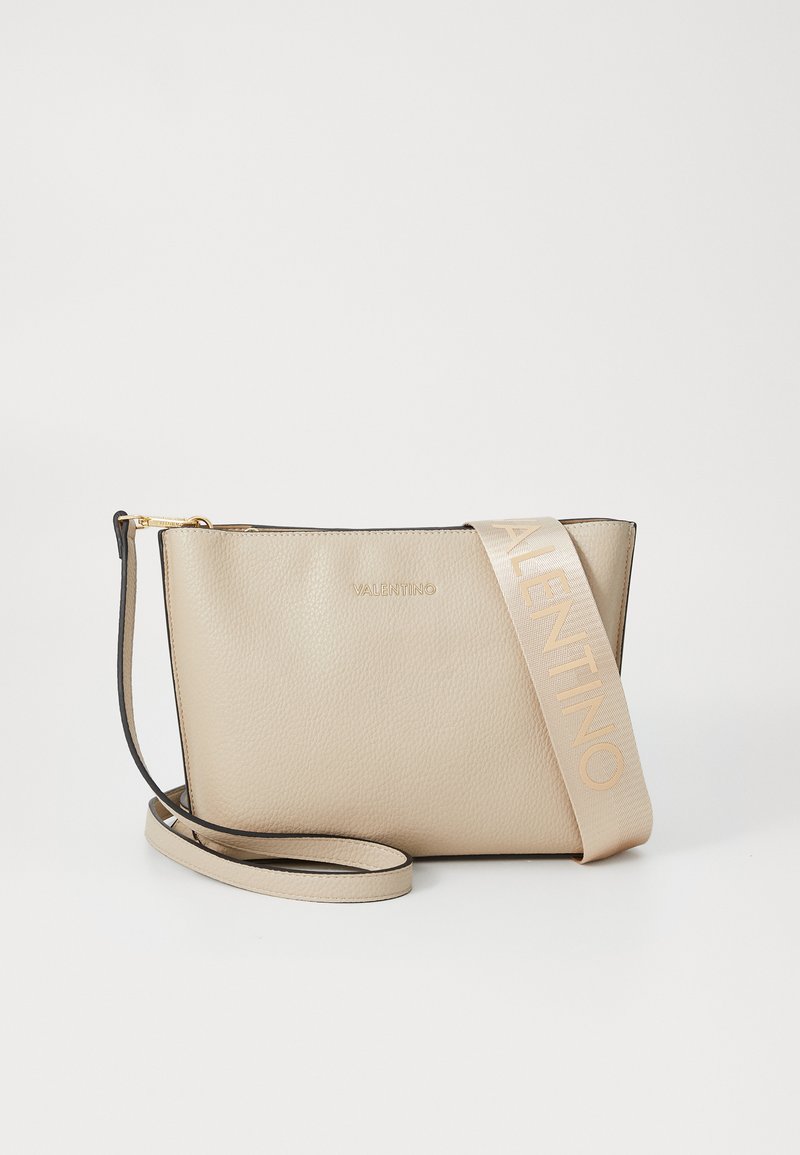 Borsa a spalla in pelle beige con una texture liscia, dotata di una cerniera in tonalità oro e di una ampia tracolla in tessuto con il marchio "VALENTINO" impresso.