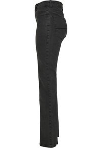 Jeans de mezclilla negra con un diseño ajustado, cinturilla de altura media, cinco bolsillos y un detalle de costura sutil a lo largo de las costuras.