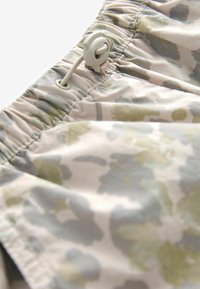 Lätta shorts med ett mjukt, blommigt mönster i dämpade gröna och grå toner. Elastisk midja med justerbar dragsko.
