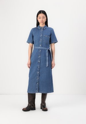 Knapper denimkjole med korte ermer, krage, brystlomme og belte i midjen. Kjolen er ankellang og i en mellomblå farge.