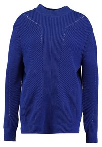 Modrý pletený svetr s vysokým výstřihem, který má texturované vzory a otevřené stehny na ramenou a bocích. Dlouhé rukávy.