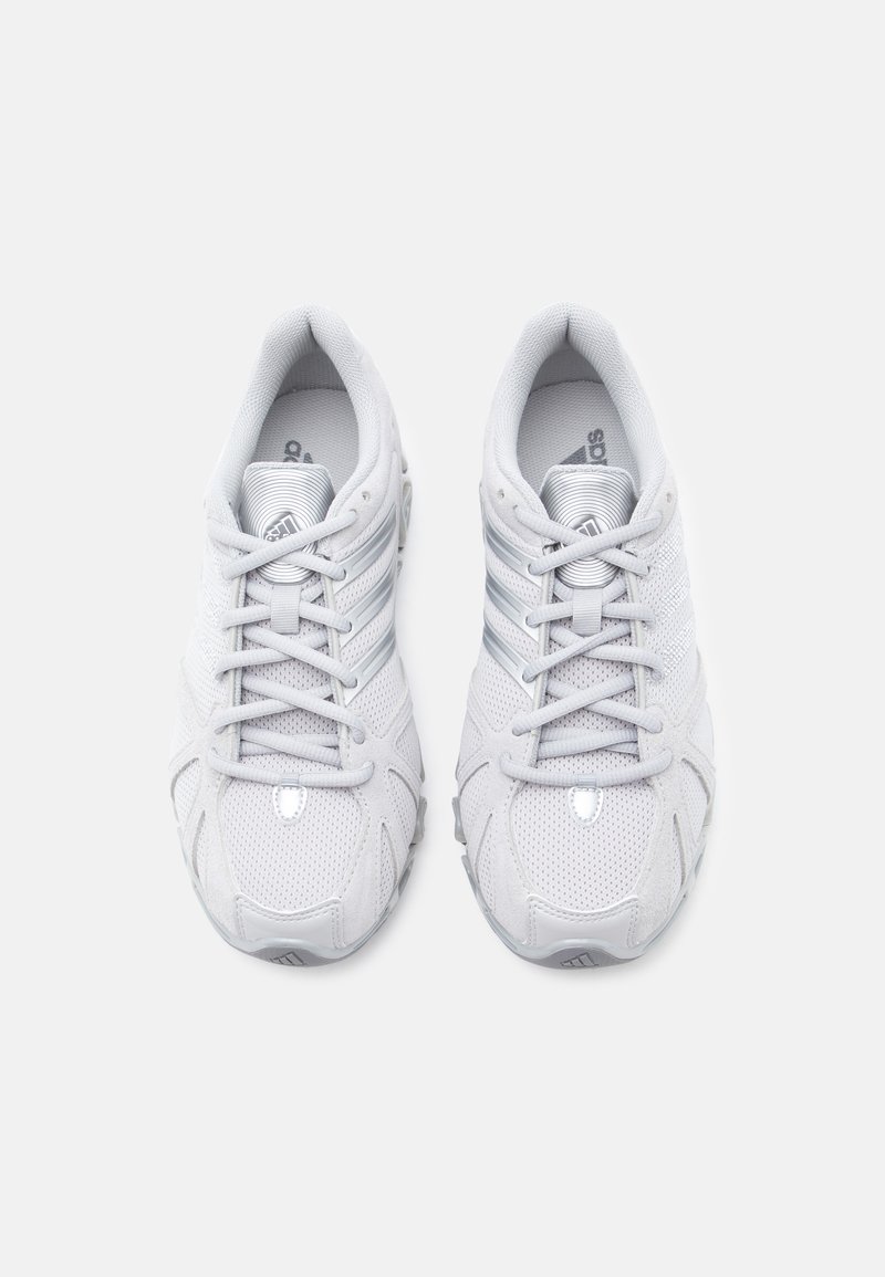 Scarpe da ginnastica bianche con tomaia in mesh, dettagli argentati riflettenti, suola imbottita e sistema di allacciatura tradizionale per una calzata sicura.