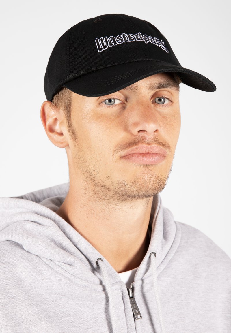 Črna bejzbola kapa z izvezeno besedo "Wasted" v beli barvi, s krivim šiltom in strukturirano zasnovo. Noso z sivo kapuco.