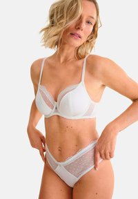 Wit lingerieset met een kanten bh met gestippelde meshpanelen en bijpassende high-waisted slips met kantaccenten en een gladde afwerking.