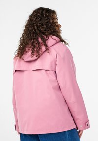 Hellrosa wasserdichte Jacke mit Kapuze, ausgestattet mit einer hinteren Klappe, Druckknöpfen an den Bündchen und einer glatten, matten Oberfläche.